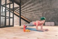 Green-haired sportswoman doing morning plank after workout