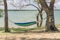 Lakeside hammock hanging between trees sunny day