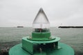 Green harbor light with the sea in the background