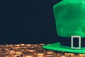 green hat on golden coins isolated on black, st patricks day concept