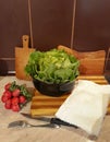 Green head salad and red radish, fork, knife and kitchen towel Royalty Free Stock Photo