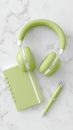 Green headphones and matching notebook on marble surface Royalty Free Stock Photo