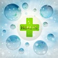 Green health cross in bubble at winter snowfall