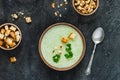 Green healthy cream soup with broccoli, crackers, cashew, parsley. Top view