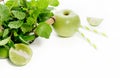 Green healthy drink ingredients on white background: lime, aapple, fresh mint and colorful paper straws. Vegetarian food. Detox Royalty Free Stock Photo