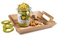 Green healthy fruit smoothie layered in glass with chia seed pudding topped with star shaped banana and kiwi slices on wooden tray