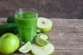 Green healthy smoothie in a glass with spinach, apple, cucumber and lime over rustic wooden table. detox drink Royalty Free Stock Photo