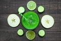 Green healthy smoothie in a glass with spinach, apple, cucumber and lime with a straw over rustic wooden table. top view Royalty Free Stock Photo