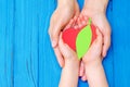 Green heart in hands of adult and child Royalty Free Stock Photo