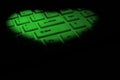 Green heart made of bright light on a computer keyboard. The concept of congratulations on Valentine`s Day, digital love, dating Royalty Free Stock Photo