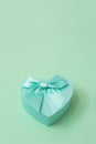 Green heart shape decorative gift box with bow on mint green background. Valentine`s day, love, wedding, Royalty Free Stock Photo