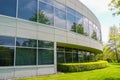 Green hedge and mowed lawn along round shaped wall of the office building Royalty Free Stock Photo