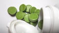 green herbal round and flat pills lie on a light background