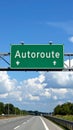 Green highway sign with the word Autoroute pointing forward and down on a clear day Royalty Free Stock Photo