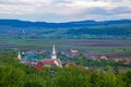 Green hills in a mountain valley. Summer landscape. At the foot of the mountains is a small village with small houses Royalty Free Stock Photo