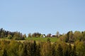 a green hillside with trees and a barn on it is seen here