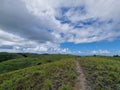 green hilltop with clouds and blue sky above Royalty Free Stock Photo