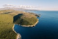 Green hilly rugged coast of the blue sea. Drone