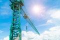 Green hoisting crane on blue sky background with clouds, close up of The Tower Crane. The construction crane with the cloud sky ba