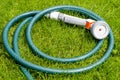 Green hose for watering lies on grass, lawn