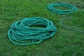 Green hoses for lawn irrigation, folded into several coils Royalty Free Stock Photo