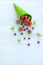 Green ice cream cone with strawberries and currants and gooseberries, filled with strawberries it fell out of the horn Royalty Free Stock Photo