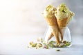 Green ice cream in waffle cone with chocolate and pistachio nuts on grey stone background. Summer food concept, copy Royalty Free Stock Photo