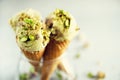 Green ice cream in waffle cone with chocolate and pistachio nuts on grey stone background. Summer food concept, copy Royalty Free Stock Photo