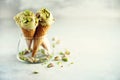 Green ice cream in waffle cone with chocolate and pistachio nuts on grey stone background. Summer food concept, copy Royalty Free Stock Photo