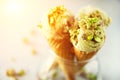 Green ice cream in waffle cone with chocolate and pistachio nuts on grey stone background. Summer food concept, copy Royalty Free Stock Photo