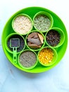 Green Indian food ingredients box with mustard, split chickpeas,fennel and cummin seeds,gloves and cinnamon