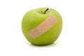 Green injured apple with plaster Royalty Free Stock Photo