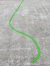 Green irrigation hose on a reinforced concrete slab