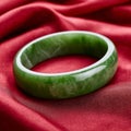 Green jade bangle bracelet on red fabric background. Royalty Free Stock Photo