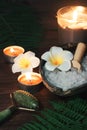 Green jade massage roller against the background of turn signals and burning candles on the table Royalty Free Stock Photo