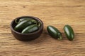 Green jalapeno peppers on a bowl over wooden table Royalty Free Stock Photo