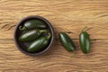 Green jalapeno peppers on a bowl over wooden table Royalty Free Stock Photo