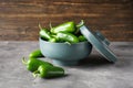 Green jalapeno peppers in a ceramic bowl on a gray wooden background Royalty Free Stock Photo