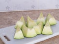 Green japanese melon was cut or divided on a white block in kitchen