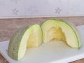 Green japanese melon was cut or divided on a white block in kitchen