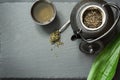 Green japanese tea on black slate. Black teapot with dry green tea. Tea preparation. Top view with copy space. Royalty Free Stock Photo