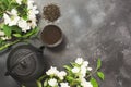 Green jasmin tea and jasmine flowers, cup of green tea on black. Top view. Teatime.