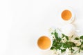 Green jasmin tea and jasmine flowers, cup of green tea on white background. Top view. Copy space.