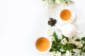 Green jasmin tea and jasmine flowers, cup of green tea on white. Top view. Teatime. Royalty Free Stock Photo