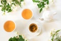 Green jasmin tea and jasmine flowers, cup of green tea on white. Top view. Teatime. Royalty Free Stock Photo