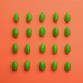 Green jelly beans on coral, flat lay Royalty Free Stock Photo