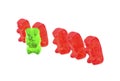 Green jelly bear with other red jelly bears isolated on white background