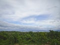 Green jungle and sea in the distance under a cloudy sky