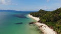 Green jungle and stony beach near sea. Tropical rainforest and rocks near calm blue sea on white sandy shore of Koh Samui paradise Royalty Free Stock Photo