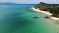 Green jungle and stony beach near sea. Tropical rainforest and rocks near calm blue sea on white sandy shore of Koh Samui paradise